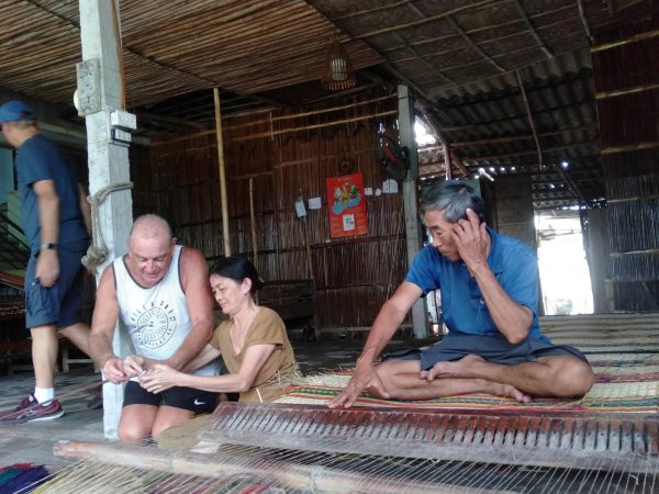 Artisan weaving traditional mats in Hoi An
