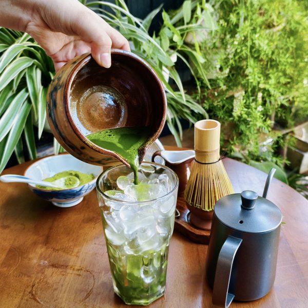 Pouring freshly whisked matcha over ice