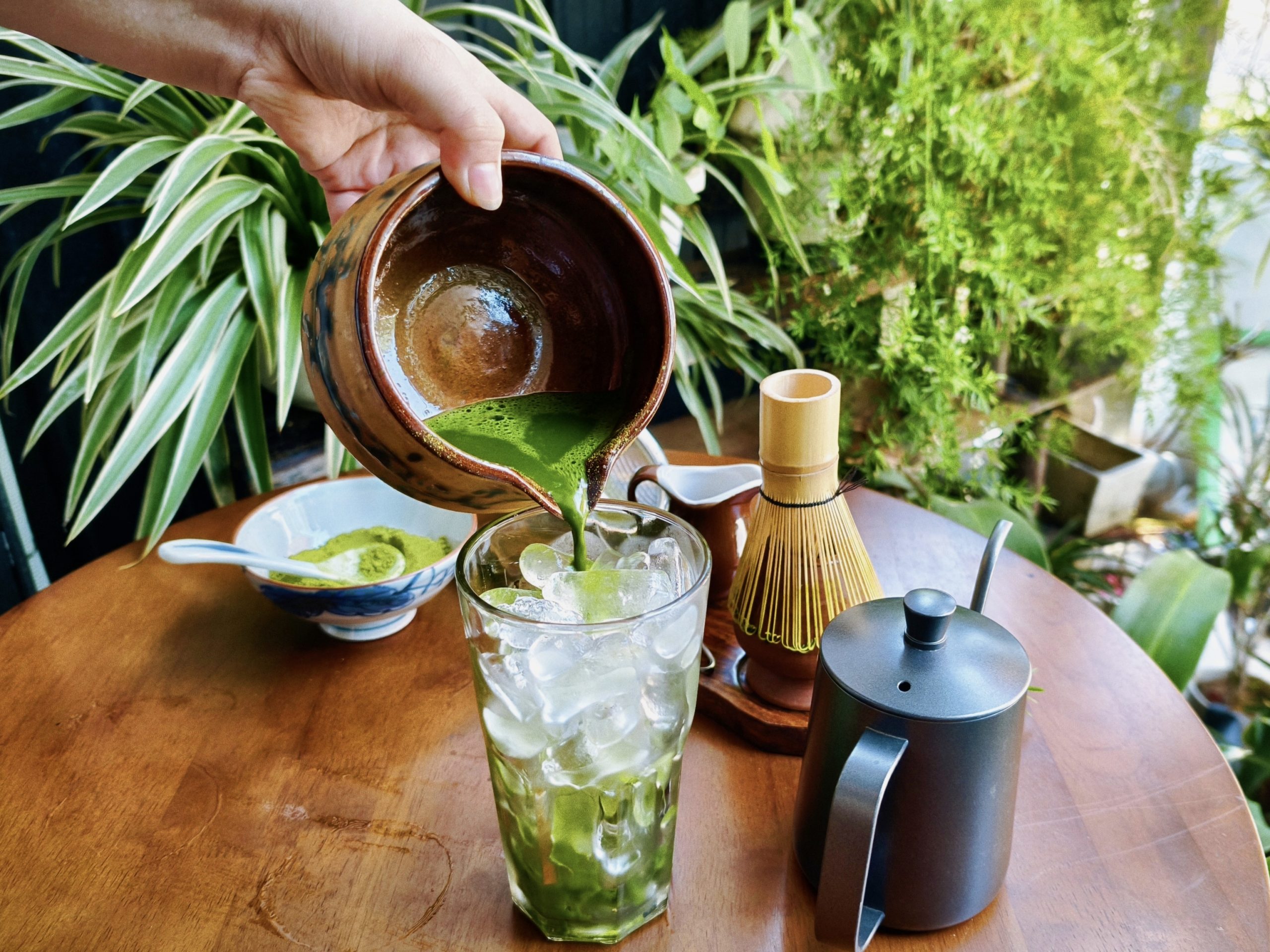 Pouring freshly whisked matcha over ice