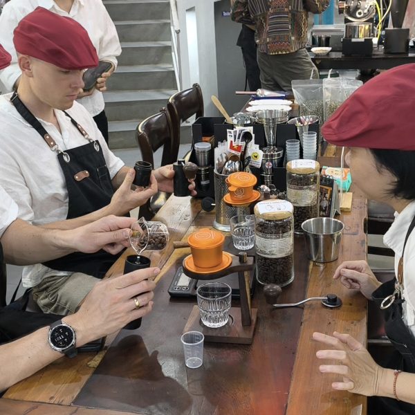 Guests grinding and tasting coffee while learning Vietnamese phin brewing in Hoi An