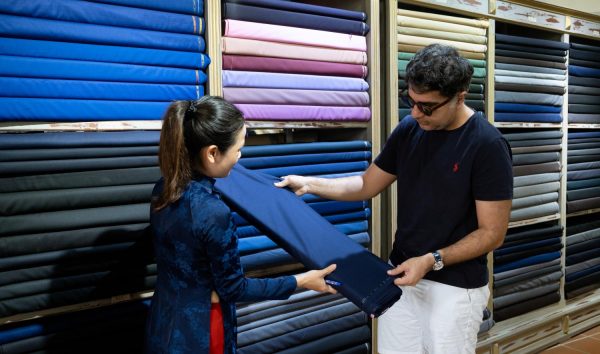 Customer getting measured at a tailor shop in Hoi An