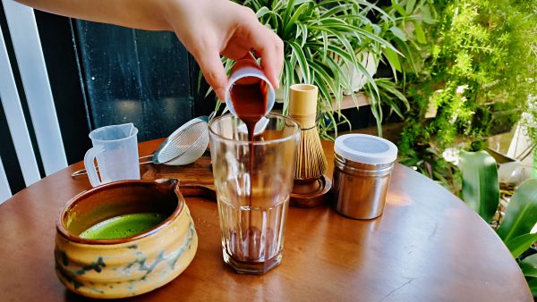 Pouring chocolate to make a matcha chocolate drink