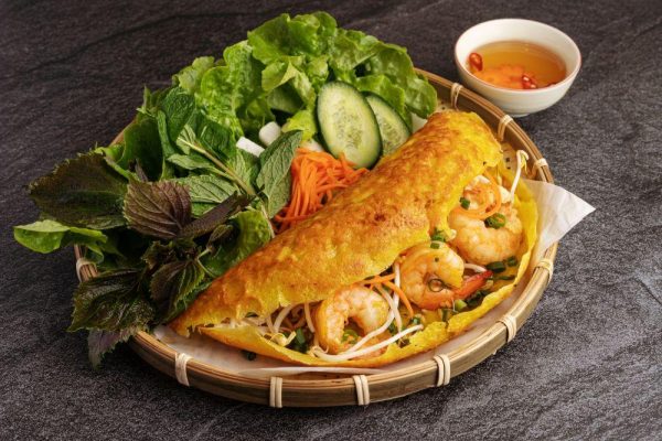 Vietnamese banh xeo crispy pancakes served with fresh herbs and dipping sauce