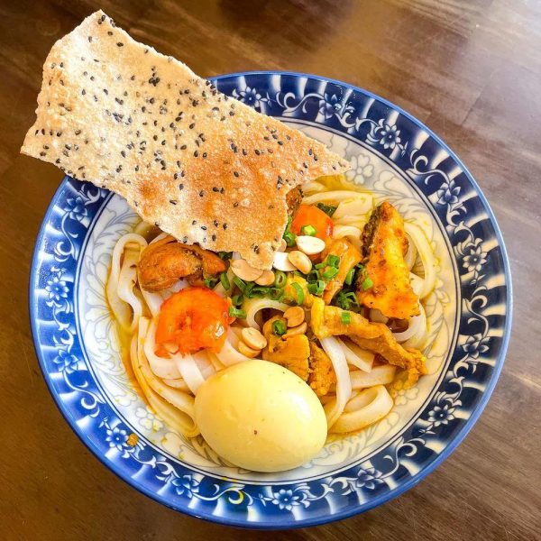 Vietnamese Mi Quang noodles with shrimp, pork, fresh herbs and rice crackers