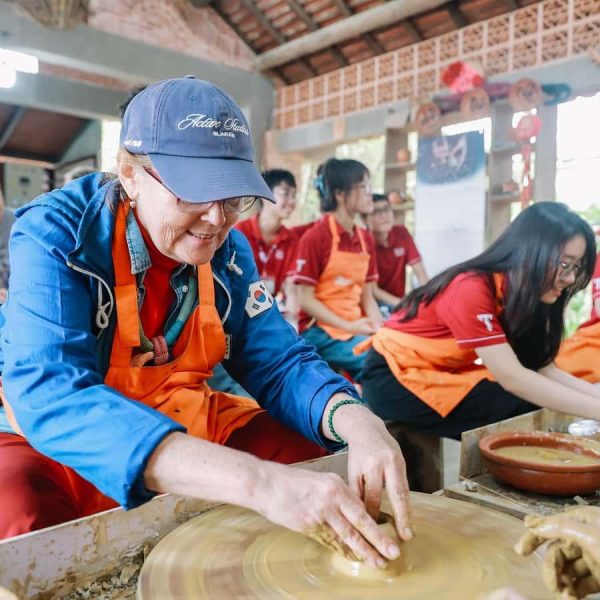 Visitor shaping a clay pot on a pottery wheel at Thanh Ha village in Hoi An